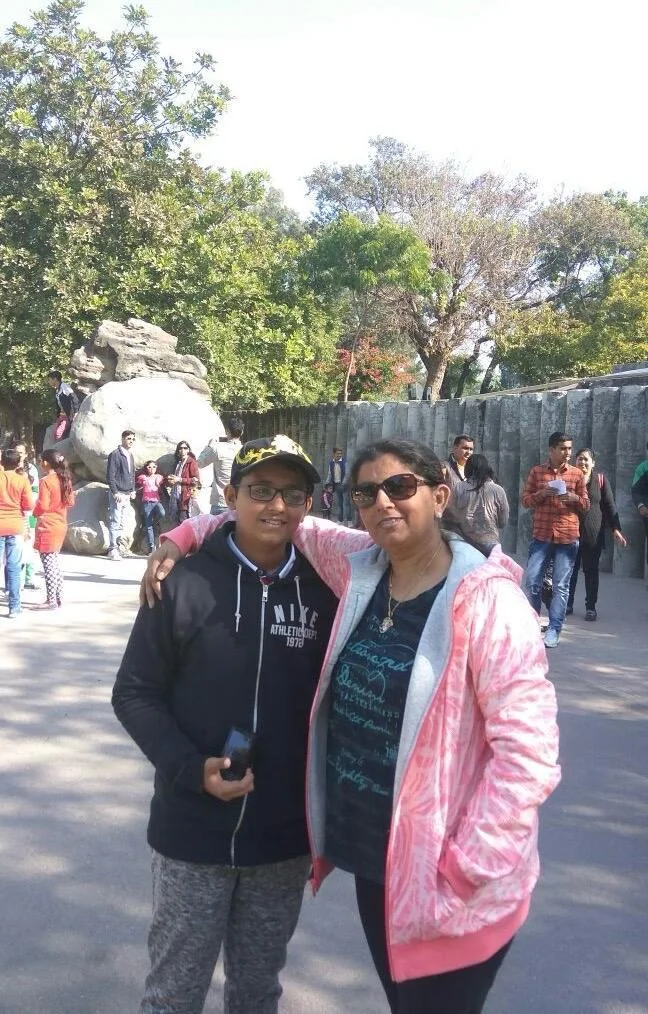 Ayush as a child standing beside his mother at a zoo