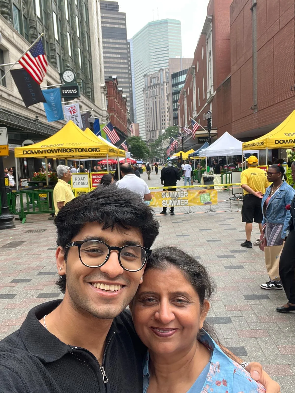 Ayush's mother outdoors with a small flower tucked behind her ear